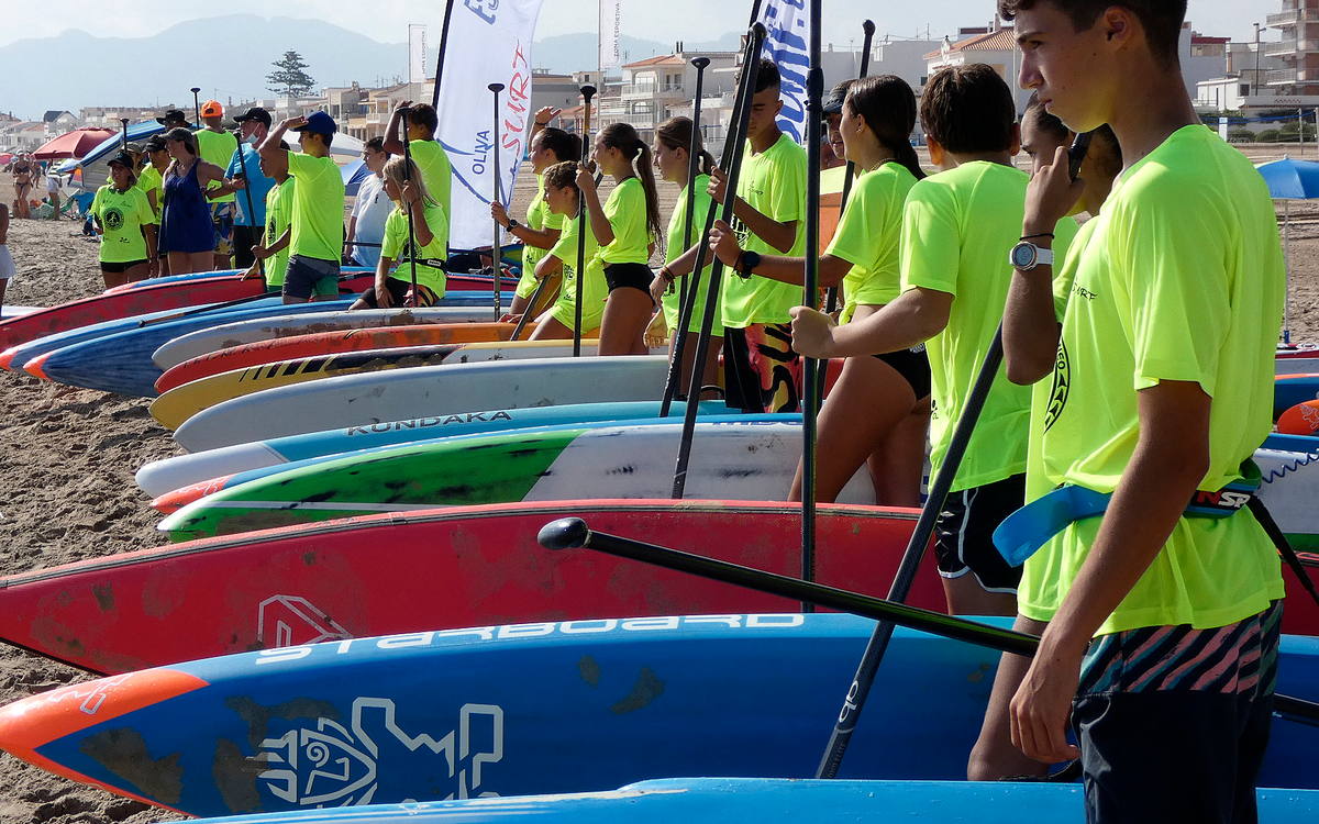 Adolescentes de 15 a 17 años preparando las tablas de paddle surf en la playa