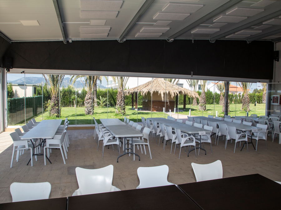 Comedor del albergue con las mesas preparadas y vistas al jardín