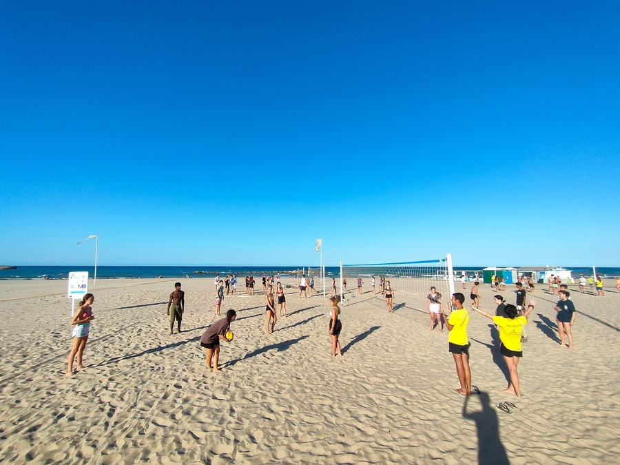 Partido de vóley playa en la arena durante la tarde