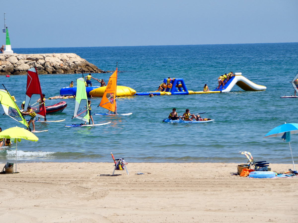 Parque acuático hinchable, piraguas y velas frente a la playa de Oliva