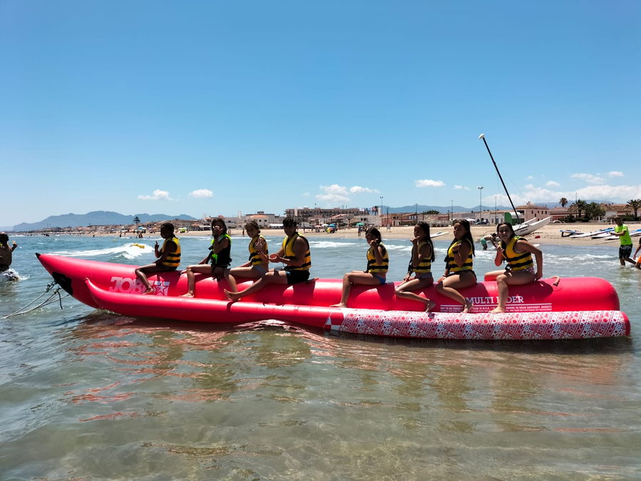 Campistas montados en la banana hinchable frente a la playa de Oliva