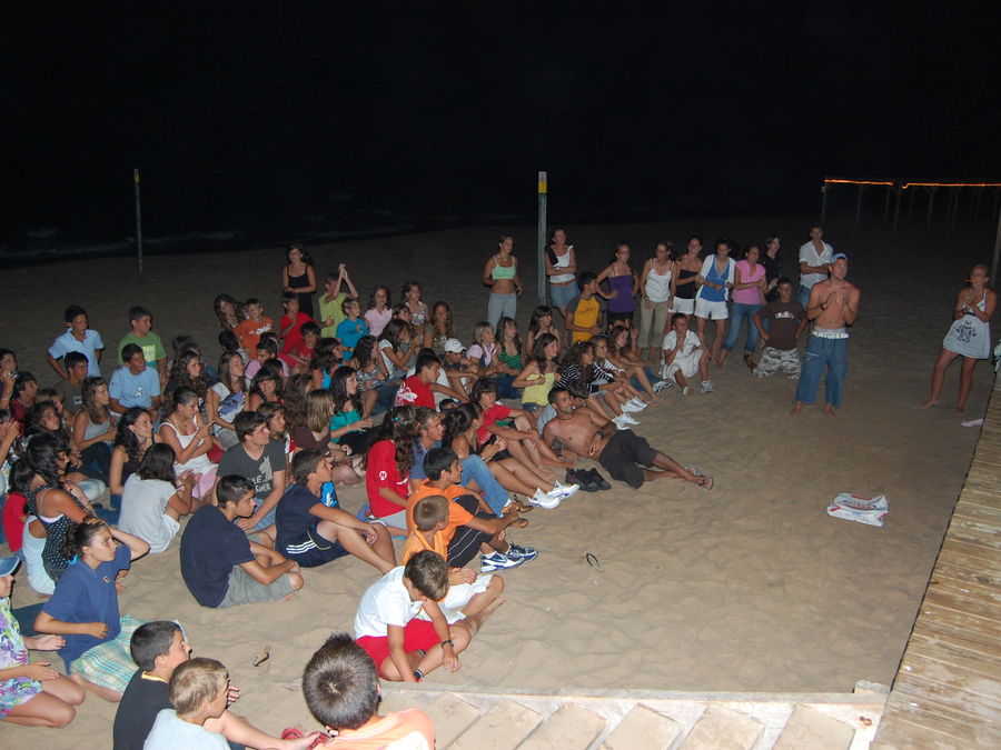 Velada nocturna del campamento con todo el grupo reunido en la playa